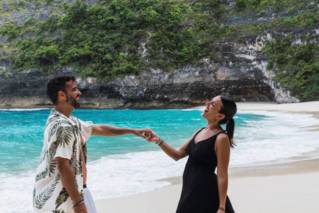 Happy couple holding hands laughing on Nusa Penida beach model released, Symbolfoto property released, PNAF06956