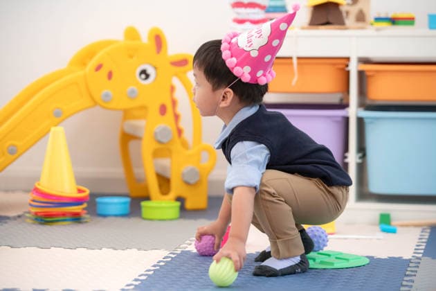 Ein kleiner Junge mit einer Geburtstagskappe spielt mit Spielzeug Little boy wearing a birthday hat playing with toys, supporting development through joyful play (License=RF) ,model released, Symbolfoto Copyright: xZoonar.com SunanxWongsa-ngax 24901931 ,model released, Symbolfoto ,property released