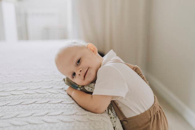 Happy child plays with a pillow in a cozy bedroom indoors model released, Symbolfoto property released, VBUF00774