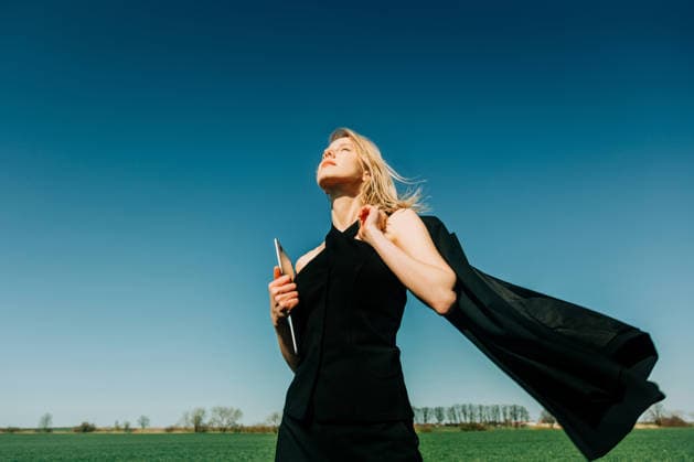 Businesswoman holding laptop in a green wheat field expressing freedom model released, Symbolfoto, VSNF04758
