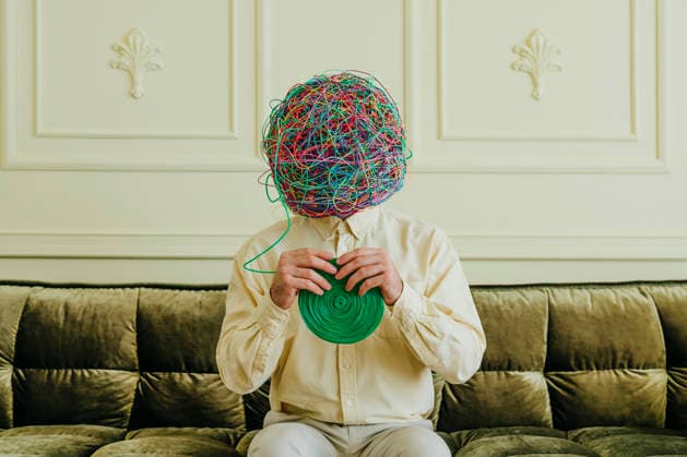Man with mask of chaotic thoughts solving tangled wires model released, Symbolfoto property released, YTF02575