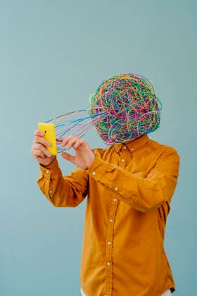Man with chaotic thoughts using smart phone against blue background model released, Symbolfoto property released, YTF02616