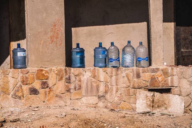 Marsa alam, egypt 21 april 2026: water bottles are lined up on a stone wall, representing hydration and resource management in a warm, dry desert region Water bottles stored in outdoor desert environment, marsa alam Copyright: xx Egitto edit 859