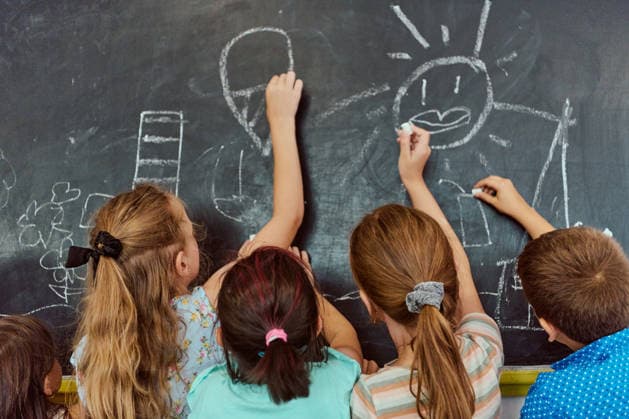 Kinder, die während einer gemeinsamen Kunstaktivität im Klassenzimmer gemeinsam auf einer Tafel malen Five elementary-aged children reach up to draw on a chalkboard, sharing imaginative chalk drawings and playful collaboration that highlights creativity, friendship and hands-on classroom learning. (License=RF) ,model released, Symbolfoto Copyright: xZoonar.com BENISxARAPOVICx 24925927 ,model released, Symbolfoto ,property released
