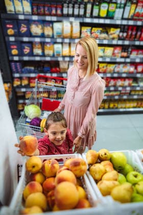 Mutter und Tochter suchen im Supermarkt frische Pfirsiche aus Mother and daughter smiling, choosing fresh fruit from a display in a grocery store (License=RF) ,model released, Symbolfoto Copyright: xZoonar.com JelenaxCvetkovicx 24945755 ,model released, Symbolfoto ,property released