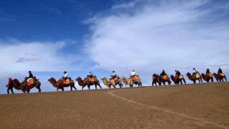 (260427) -- BEIJING, April 27, 2026 -- Tourists visit the Mingsha Mountain and Crescent Spring Scenic Area in Dunhuang City, northwest China s Gansu Province, April 27, 2026. As the May Day holiday approaches, the tourism markets across the country are heating up. (Photo by Xinhua) CHINA-HOLIDAY-TOURISM (CN) ZhangxXiaoliang 