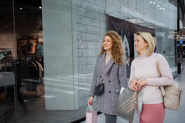 Zwei glückliche Frauen, die ihren Einkaufsbummel in einem modernen Einkaufszentrum genießen Two young adult women walking and carrying shopping bags inside a brightly lit mall (License=RF) ,model released, Symbolfoto Copyright: xZoonar.com JelenaxCvetkovicx 24959694 ,model released, Symbolfoto ,property released