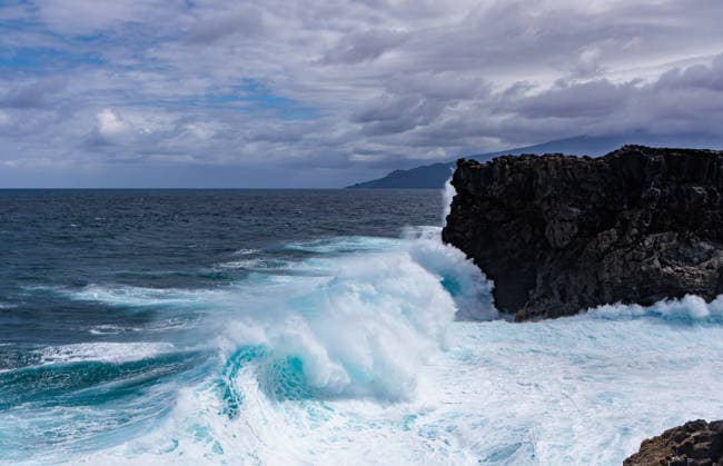Creative Highlights World Mächtige Meereswellen, die gegen dunkle vulkanische Klippen in El Hierro schlagen. Dramatische Atlantikküstenlandschaft mit weißem Meeresschaum und bewölktem Himmel. Die Kraft der Natur und das Reisekonzept *** Powerful Ocean waves, the against dark volcanic Cliffs in El Hierro Beating Dramatic Atlantic coastal landscape with white Sea foam and cloudy Sky the Force the Nature and the Travel concept 1135900375