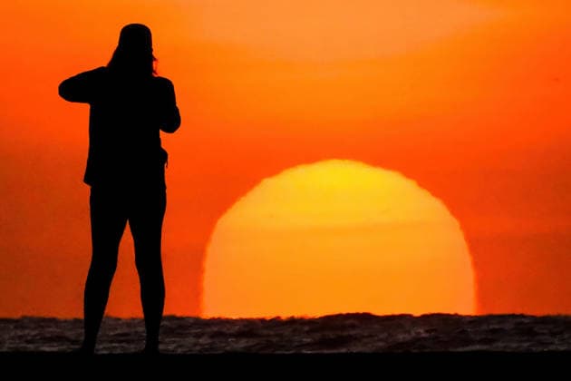 April 28, 2026, Isle Of Palms, Sc, United States: A woman silhouetted by the sun takes a photo it rise over the Atlantic Ocean on a beautiful morning on Front Beach, April 28, 2026 in Isle of Palms, South Carolina. Isle Of Palms United States - ZUMAe02_ 20260428_zaf_e02_001 Copyright: xRichardxEllisx