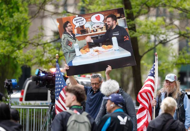 A protestor holds up a sign with a picture of New York City Mayor Zohran Mamdani as King Charles III and Queen Camilla visit the 9 11 Memorial pools in New York City on Wednesday, April 29, 2026. King Charles III and Queen Camilla will visit the nation s capital, New York City, and Virginia during the trip arranged to celebrate the United States of America s 250th anniversary of its independence.  NYP20260429802 JOHNxANGELILLO