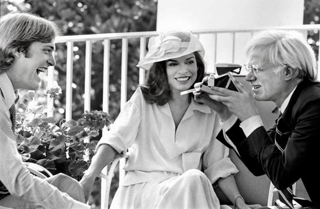July 2, 1975, Washington, Dc, USA: American artist Andy Warhol taking Polaroid picture while sitting with Jack Ford and Bianca Jagger on White House Truman Balcony, Washington, D.C., USA, Gerald R. Ford White House Photographs, July 2, 1975 Washington USA - ZUMAg145 19750702_zap_g145_001 Copyright: xJTxVintagex