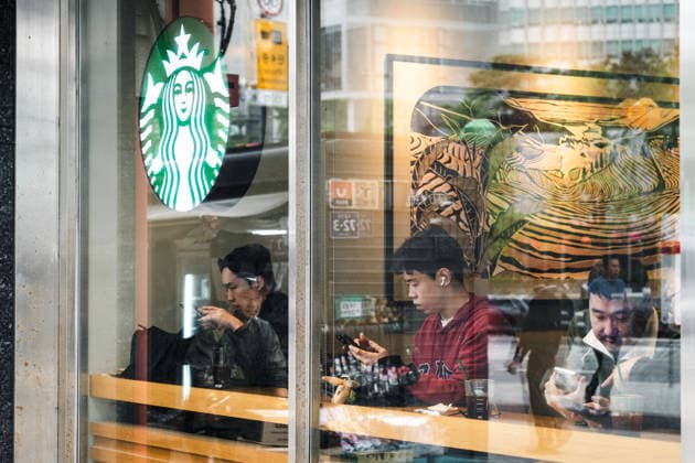 Starbucks schließt in Südkorea temporär alle Filialen, Archivbilder Seoul, South Korea April 28, 2026: Visitors sit in a Starbucks branch and use their smartphones; the cafÃ serves as a place for breaks and everyday leisure *** Besucher sitzen in einer Starbucks-Filiale und nutzen ihre Smartphones; das Cafe dient als Ort für Pause und alltägliche Freizeit