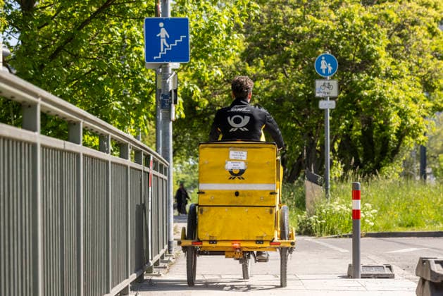 Briefträger unterwegs mit seinem Fahrrad. 29.04.2026, Stuttgart, Baden-Württemberg, Deutschland *** Letter carrier on the road with his bicycle 29 04 2026, Stuttgart, Baden Württemberg, Germany