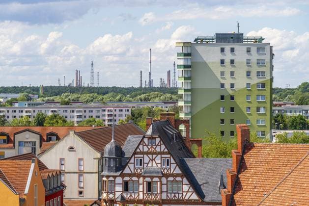 Blick vom Turm der Pfarrkirche St. Katharinen über die historische Stadtmühle im Fachwerkstil und DDR-Plattenbauten zu den Türmen und Schornsteinen der Erdöl-Raffinerie PCK, Schwedt an der Oder, Uckermark, Brandenburg, Deutschland View from the tower of the parish church of St. Katharinen over the historic half-timbered town mill and GDR prefabricated buildings to the towers and chimneys of the PCK oil refinery, Schwedt an der Oder, Uckermark, Brandenburg, Germany Copyright: imageBROKER OliverxGerhard ibxoge17409085.jpg