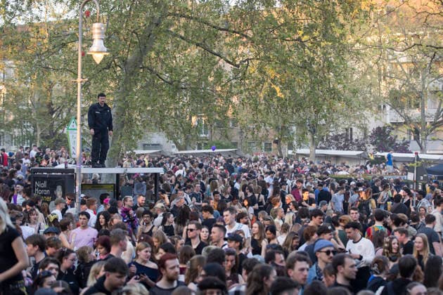 1. Mai, Impressionen aus Kreuzberg, Berlin, 01.05.2026 Ein Polizist steht auf einem Wartehäuschen und beobachtet den überfüllten Mariannenplatz nach einem Konzert der Rapperin Ikkimel auf dem Berliner Mariannenplatz am 01.05.2026. Berlin Mariannenplatz *** 1 May, Impressions from Kreuzberg, Berlin, 01 05 2026 A policeman stands on a bus shelter and observes the crowded Mariannenplatz after a concert by rapper Ikkimel on Berlins Mariannenplatz on 01 05 2026 Berlin Mariannenplatz Copyright: xBenxKriemannx