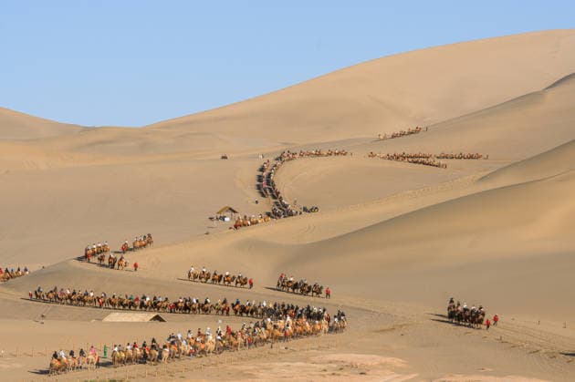 News Bilder des Tages DUNHUANG, CHINA - MAY 02: Tourists ride camels at Mingsha Mountain and Crescent Spring scenic spot during the May Day holiday on May 2, 2026 in Dunhuang, Jiuquan City, Gansu Province of China.  Copyright: xVCGx 111638796608