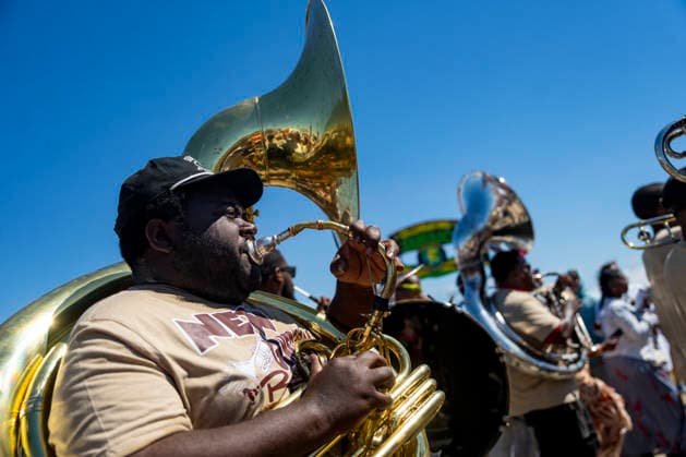 A brass band walks with members of the Zulu Social Aid and Pleasure Club walking group parade through the New Orleans Jazz and Heritage Festival at the Fairgrounds Race Courts and Slots in New Orleans, Louisiana on Sunday, May 3, 2026. Organizers expected about 400,000 to attend, but the finally tally, which won t be available for a few days, may be impacted by rain that interrupted festival operations Thursday and Friday.  NOL20260503311 BONNIExCASH