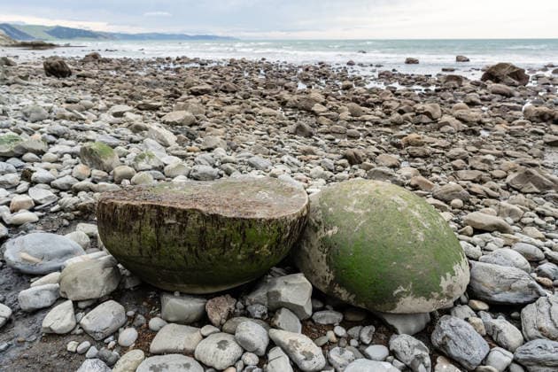 Creative Highlights World Two halves of large round rock on New Zealand coast Ocean Beach, Hawke s Bay Region, New Zealand CR_JUCR260502-1967309-01
