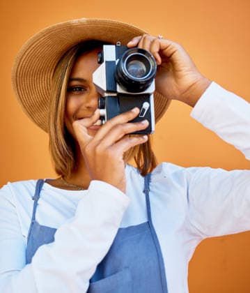 Camera, portrait and photographer woman isolated on wall background for summer beauty, holiday travel and fashion. Gen z, black person or model face with retro photography for vacation digital memory. (License=RF) ,model released, Symbolfoto  Copyright: xZoonar.com YurixArcursxpeopleimages.comx 19902418 ,model released, Symbolfoto ,property released