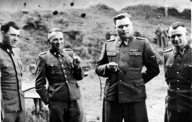 RECORD DATE NOT STATED A photograph of Dr Josef Mengele, Rudolf Höss, and Josef Kramer, key figures in the Holocaust. A photograph of Dr Josef Mengele (1911-1979), known as The Angel of Death for the medical experiments he carried out on the inmates of Auschwitz, the German Nazi concentration camp. He is pictured with Rudolf Höss, Commandant of Auschwitz, Josef Kramer, Commandant of Belsen, and an unidentified German officer. All are in SS uniforms at a Nazi concentration camp. c.1943. Editorial use only. All other uses to be cleared with the copyright owner (World History Archive), in advance., WHA_011_0107.jpg, Josef Mengele; Rudolf Höss; Josef Kramer; Auschwitz; Belsen; Nazi Germany; World War II; The Holocaust; Concentration Camps; Me Copyright: xx
