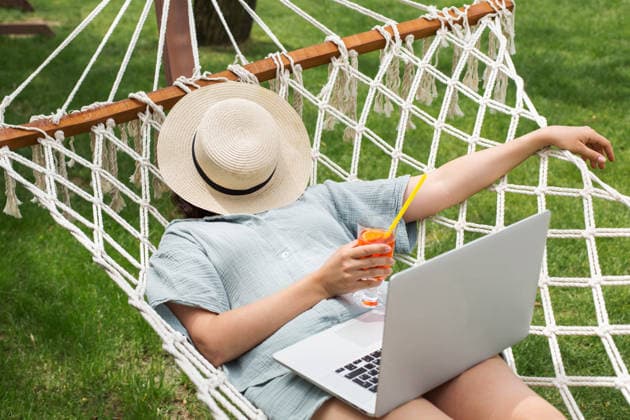 Frau, die sich mit ihrem Laptop in einer Hängematte entspannt und im Garten einen Sommercocktail in der Hand hält; Konzept für einen Urlaub mit Remote-Arbeit, das die Freiheit digitaler Nomaden, Freizeit und Wellness, mobile Produktivität sowie einen ausg Woman relaxing in hammock with laptop, holding summer cocktail in garden, remote work vacation concept expressing digital nomad freedom, leisure wellness, mobile productivity, balanced lifestyle (License=RF) ,model released, Symbolfoto Copyright: xZoonar.com EvgeniiaxGordeevax 25011474 ,model released, Symbolfoto ,property released