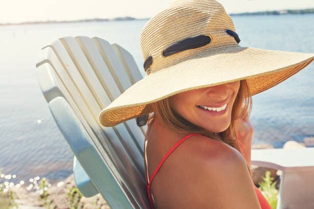 Put on your hats and take out the sunscreen. a cheerful young woman wearing a hat while being seated on a chair next to a lake outside in the sun (License=RF) ,model released, Symbolfoto  Copyright: xZoonar.com KasperxRavlox 20178718 ,model released, Symbolfoto ,property released