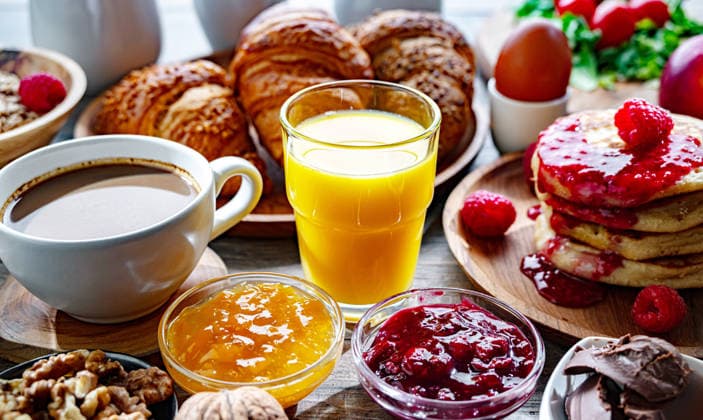 Frühstück serviert mit Kaffee, Orangensaft, Pfannkuchen, Croissant Breakfast served with coffee, orange juice, pancakes, croissants, cereals and eggs. (License=RF) Copyright: xZoonar.com monticellox 25015807
