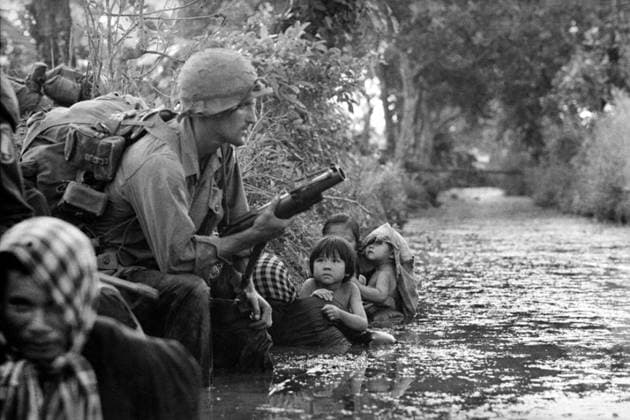 RECORD DATE NOT STATED Photograph of two South Vietnamese children gazing at an American paratrooper Photograph of two South Vietnamese children gazing at an American paratrooper holding an M79 grenade launcher as they cling to their mothers who huddle against a canal bank for protection from sniper fire in the Bao Trai area, Vietnam, 1966 Editorial use only. All other uses to be cleared with the copyright owner (World History Archive), in advance., WHA_047_0521.jpg, South Vietnamese; children; American paratrooper; M79 grenade launcher; mothers; canal bank; protection; sniper fire; Bao Trai; Vietnam; 1966; war; conflict; soldiers; civilians; fear; danger; safety; huddle; gaze; innocence; military; weapon; defense; security; historical; vin Copyright: xWorldxHistoryxArchivex