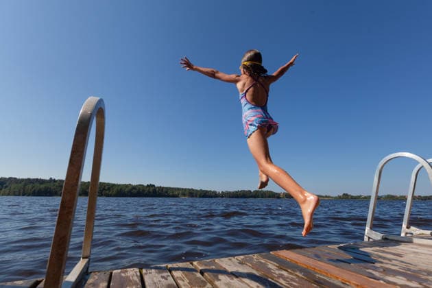 Ein begeistertes Kind springt während der Sommerferien fröhlich vom Steg in den blauen See Ein begeistertes Kind springt während der Sommerferien fröhlich vom Steg in den blauen See (License=RF) ,model released, Symbolfoto Copyright: xZoonar.com ElenaxSkorobogatovax 25031383 ,model released, Symbolfoto ,property released