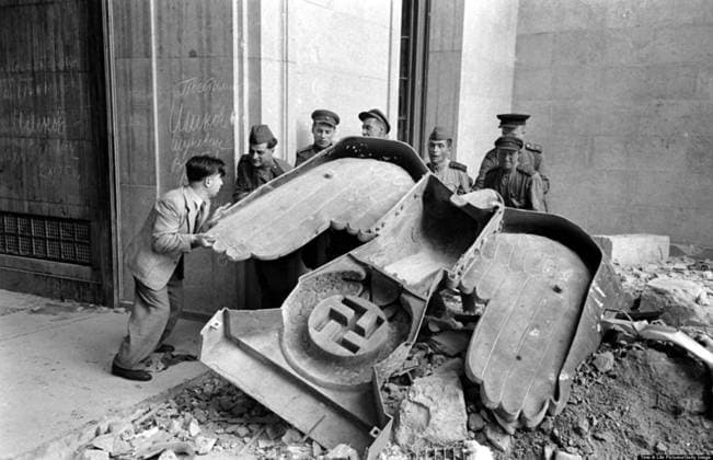 RECORD DATE NOT STATED Photograph of Russian soldiers and a civilian struggle to move a large bronze Nazi Party eagle Photograph of Russian soldiers and a civilian struggle to move a large bronze Nazi Party eagle that once loomed over a doorway of the Reich Chancellery, Berlin. Dated 1945 Editorial use only. All other uses to be cleared with the copyright owner (World History Archive), in advance., WHA_068_0428.jpg, Russian soldiers; civilian; struggle; move; large bronze; Nazi Party eagle; Reich Chancellery; Berlin; 1945; World War II; historical; monument; war; conflict; victory; teamwork; cooperation; effort; strength; power; symbol; history; military; occupation; Europe; Germany; Soviet Union; allies; liberation; resistance; iconic. Copyright: xWorldxHistoryxArchivex