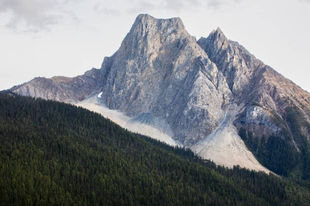 Creative Highlights World Rugged Mountain Peak Rising Above Dense Evergreen Forest Landsca Banff, Alberta, Canada CR_NCJL2605101F-2015321-01