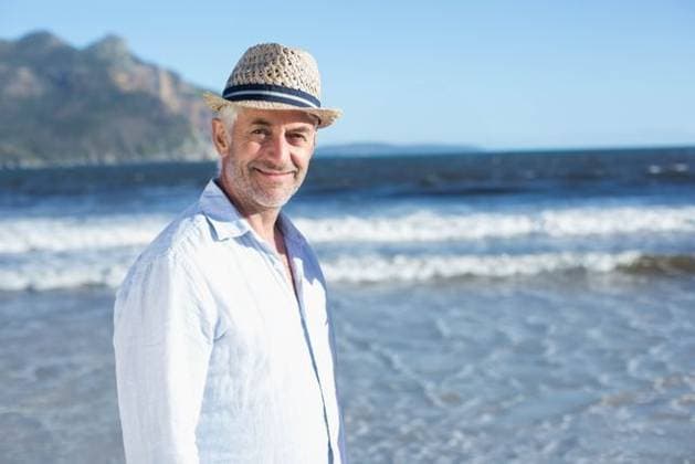 Man standing in shallow water at sandy beach wearing linen shirt and straw hat, looking, model released, 03.04.2014 06:00:00, 8079340 Copyright: xIMS-251121_2xcreatorid:x21x 8079340