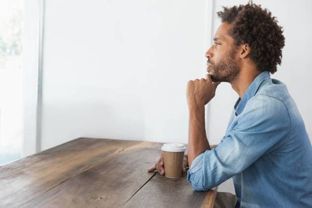 Mid adult African American man sitting at wood table holding coffee cup, gazing right, copy space, model released, property released, 13.02.2014 06:00:00, 8079518 Copyright: xIMS-251121xcreatorid:x20x 8079518