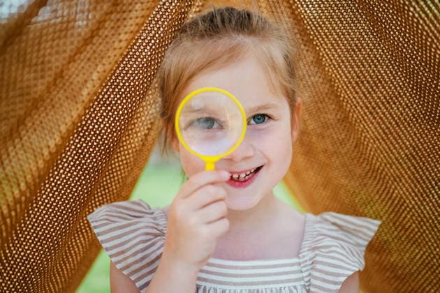 Little girl with magnifying glass in a blanket tent outdoors Corby, England, United Kingdom CR_ATMT260518-2032797-01 ,model released, Symbolfoto
