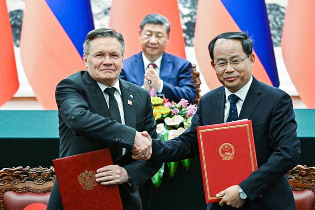 CHINA, BEIJING - MAY 20, 2026: Alexei Likhachev (L), Director General of the Rosatom State Atomic Energy Corporation, and Shan Zhongde, Chairman of the China Atomic Energy Authority, shake hands during a ceremony to sign joint documents from bilateral talks at the Great Hall of the People, with China s President Xi Jinping in the background. Vladimir Putin, President of Russia, makes an official visit to mark 25 years since the 2001 Treaty of Good Neighbourliness and Friendly Cooperation between Russia and China. Kristina Solovyova POOL TASS  92773876