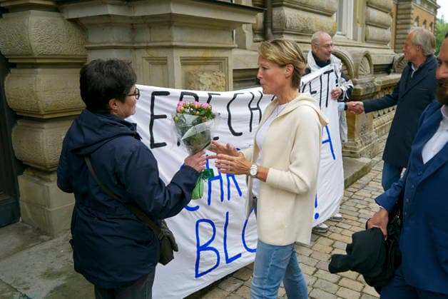 CNTV BLOCK- Unterstuetzer von Frau Block ubergeben einen Blumenstrauss an die Angeklagte mit dem Transparent Aufschrift Gerechtigkeit fuer Christina Block, Christina Block Unternehmerin und Gerhard Delling stehen vom Gericht auf der Strasse 20.05.2026 beim Prozess wegen mutmasslicher Kindesentfuehrung im Landgericht Hamburg Strafjustizgebaeude Entfuehrungsfall der Block Kinder Hamburg Deutschland *** CNTV BLOCK Supporters of Ms. Block hand over a bouquet of flowers to the defendant with the banner inscription Justice for Christina Block, Christina Block entrepreneur and Gerhard Delling stand from the court on the street 20 05 2026 at the trial for alleged child abduction in the district court of Hamburg criminal justice building abduction