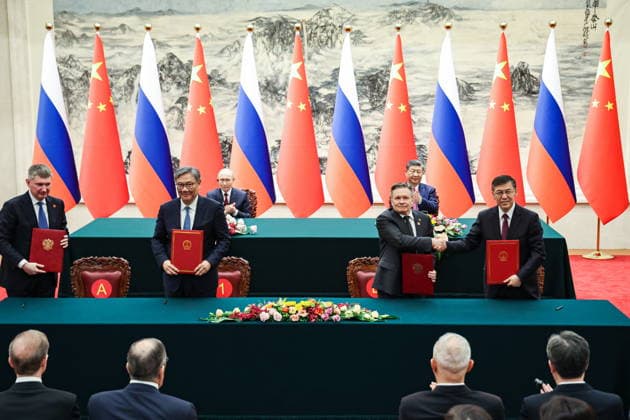 CHINA, BEIJING - MAY 20, 2026: Maxim Reshetnikov (L front), Economic Development Minister of Russia, and Alexei Likhachev (2nd R front), Director General of the Rosatom State Atomic Energy Corporation, sign joint documents following bilateral talks at the Great Hall of the People, with Presidents Vladimir Putin and Xi Jinping (L-R) of Russia and China respectively in the background. Putin s official visit marks 25 years since the 2001 Treaty of Good Neighbourliness and Friendly Cooperation between Russia and China. Alexander Kazakov Russian Presidential Press and Information Office TASS  92776407