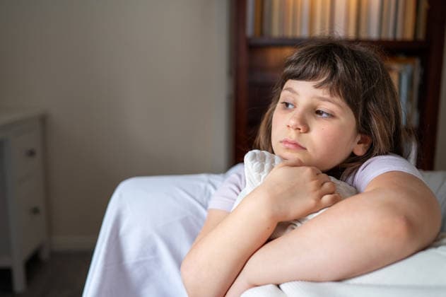 Pensive girl resting chin on pillow while sitting at home Corby, England, United Kingdom R_JNDO260514-1996185-01 ,model released, Symbolfoto