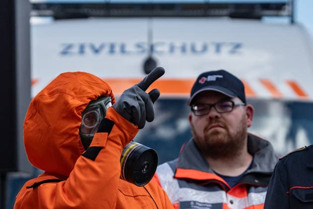 Person mit Schutzanzug und Atemschutzmaske vor einem Fahrzeug dfes Ziviklschutzes;Vorstellung Pakt für den Bevölkerungsschutz durch Bundesinnenminister und Verteidigungsminister mit Übergabe von 13 Einsatzfahrzeugen an den Zivilschutz, Berlin Berlin Deutschland Hauptbahnhof, Washingtonplatz *** Person with protective suit and breathing mask in front of a civil defense vehicle Presentation of the Civil Protection Pact by the Federal Minister of the Interior and the Minister of Defense with handover of 13 emergency vehicles to the civil defense, Berlin Berlin Germany Central Station, Washingtonplatz