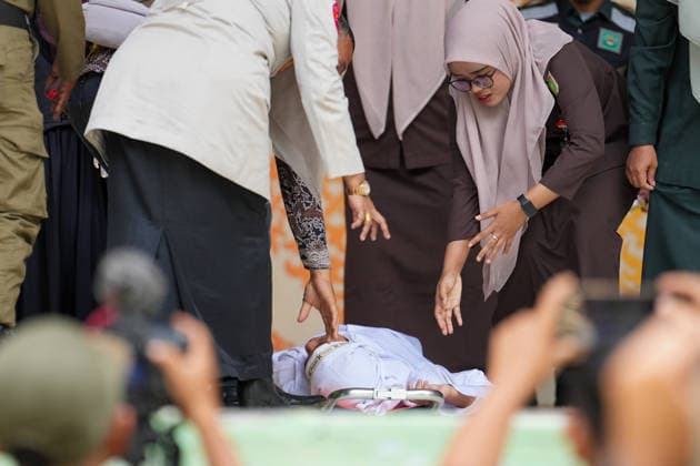 May 21, 2026, Kuta Alam, Banda Aceh, Indonesia: Officers assist a Sharia violator for adultery who is in pain after receiving 100 lashes in Banda Aceh, Aceh Province, Indonesia, on Thursday. The caning was imposed after being found guilty of violating Sharia law in Aceh. The public caning serves as a form of education and transparency in the implementation of punishment, guaranteed by the Aceh Qanun (Aceh Law), which was passed in 2014. Kuta Alam Indonesia - ZUMAi115 20260521_zip_i115_043 Copyright: xMuhammadxIqbalx