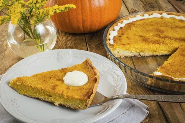 Thanksgiving Kürbiskuchenstück auf weißem Teller, Leinenserviette, Glasbackform, Vase, gelbe Blumen auf Holzuntergrund Thanksgiving pumpkin pie slice on white plate, linen napkin, glass baking dish, vase, yellow flowers on a wooden background Copyright: imageBROKER TasiPas ibxiqx17670005.jpg