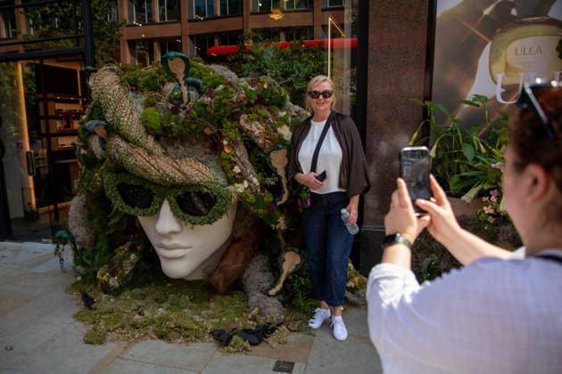 May 22, 2026, London, United Kingdom: Members of the public pose for photographs in-front of floral displays during the RHS Chelsea Flower Show. After several days of unsettled weather, large crowds gathered along Sloane Street and the surrounding areas on the penultimate day of the 2026 RHS Chelsea Flower Show to view the elaborate floral displays created for the annual event. Visitors lined the streets of Chelsea as retailers, hotels and restaurants unveiled large-scale made from fresh flowers and plants, continuing a tradition that has become closely associated with the world-famous horticultural show. London United Kingdom - ZUMAs197 20260522_aaa_s197_011 Copyright: xJamesxWilloughbyx