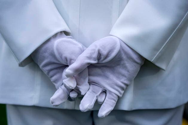 A service members looks on with wet gloves during the U.S. Naval Academy Graduation and Commissioning Ceremony at the U.S. Naval Academy in Annapolis, Maryland on Friday, May 22, 2026. The Naval Academy has a total of 1059 graduates.  ANN20260522335 BONNIExCASH