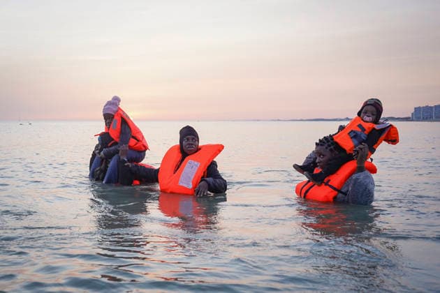 May 23, 2026, Dunkirk, Nord, France: Dunkirk, France. Migrants carrying children in the sea wait to board an inflatable boat at the beach at Dunkirk, while attempting to cross the English Channel. More than 200,000 migrants have crossed the Channel in small boats since 2018. Dunkirk France  - ZUMAl94_ 20260523_zaf_l94_038 Copyright: xIoannisxAlexopoulosx