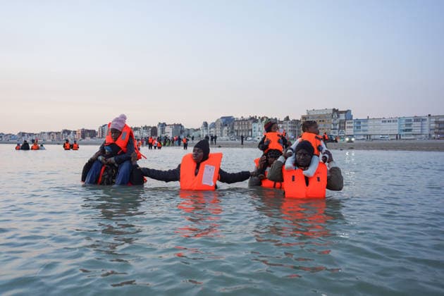 May 23, 2026, Dunkirk, Nord, France: Dunkirk, France. Migrants carrying children in the sea wait to board an inflatable boat at the beach at Dunkirk, while attempting to cross the English Channel. More than 200,000 migrants have crossed the Channel in small boats since 2018. Dunkirk France  - ZUMAl94_ 20260523_zaf_l94_065 Copyright: xIoannisxAlexopoulosx