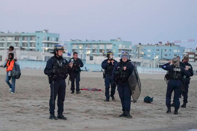 May 23, 2026, Dunkirk, Nord, France: Dunkirk, France. Riot control police (CRS) watch on as migrants board an inflatable boat at the beach at Dunkirk, while attempting to cross the English Channel. More than 200,000 migrants have crossed the Channel in small boats since 2018. Dunkirk France  - ZUMAl94_ 20260523_zaf_l94_066 Copyright: xIoannisxAlexopoulosx