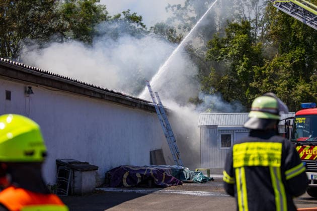 Feuer in Schützenverein in Messel ausgebrochen Am 23.05.2026 brannte auf dem Gelände des Schützenclubs Wildpark bei Messel ein Teil der Schießbahn sowie ein Gebäude. Die Feuerwehr teilte mit, dass niemand verletzt wurde. Der Alarm ging um 12:15 Uhr ein, rund 60 Einsatzkräfte aus mehreren Gemeinden waren vor Ort. Bei den Löscharbeiten kam es zu Explosionen, die zunächst für Munitionsdetonationen gehalten wurden; später stellte sich heraus, dass geplatzte Eternitplatten in der Dachkonstruktion die Ursache waren. Zur Brandursache lagen zunächst keine gesicherten Angaben vor, die Polizei ermittelt. Die Hitze machte den Einsatzkräften zu schaffen und sorgte für einen hohen Kräfteansatz. Messel Hessen Deutschland *** Fire breaks ou