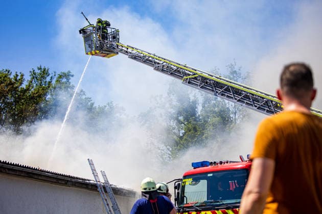 Feuer in Schützenverein in Messel ausgebrochen Am 23.05.2026 brannte auf dem Gelände des Schützenclubs Wildpark bei Messel ein Teil der Schießbahn sowie ein Gebäude. Die Feuerwehr teilte mit, dass niemand verletzt wurde. Der Alarm ging um 12:15 Uhr ein, rund 60 Einsatzkräfte aus mehreren Gemeinden waren vor Ort. Bei den Löscharbeiten kam es zu Explosionen, die zunächst für Munitionsdetonationen gehalten wurden; später stellte sich heraus, dass geplatzte Eternitplatten in der Dachkonstruktion die Ursache waren. Zur Brandursache lagen zunächst keine gesicherten Angaben vor, die Polizei ermittelt. Die Hitze machte den Einsatzkräften zu schaffen und sorgte für einen hohen Kräfteansatz. Messel Hessen Deutschland *** Fire breaks ou