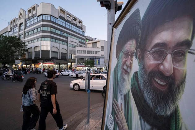 Daily Life In Iran Amid Threat About New Possible War Iranian youths walk past portraits of Iran s late and new Supreme Leaders Ayatollah Ali Khamenei and Ayatollah Mojtaba Khamenei in a business district in downtown Tehran, Iran, on May 22, 2026. U.S. President Donald Trump has indicated the possibility of military action against Iran if no agreement is reached with Iranian officials. Tehran Tehran Iran  Copyright: xMortezaxNikoubazlx originalFilename: nikoubazl-dailylif260522_nppoD.jpg