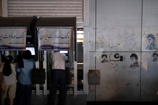 Daily Life In Iran Amid Threat About New Possible War People use ATM machines outside the Saderat Bank of Iran, which is covered with graffiti depicting portraits of Iran s late and new Supreme Leaders Ayatollah Ali Khamenei and Ayatollah Mojtaba Khamenei, in a business district in downtown Tehran, on May 22, 2026. This occurs as U.S. President Donald Trump discusses the possibility of military action against Iran if no agreement is reached with Iranian officials. Tehran Tehran Iran  Copyright: xMortezaxNikoubazlx originalFilename: nikoubazl-dailylif260522_np4MW.jpg